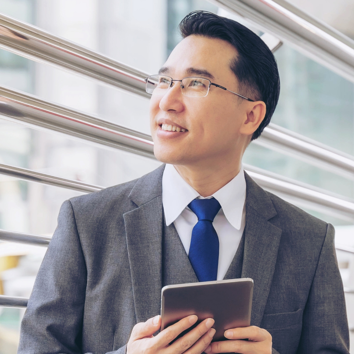 Asian-American executive looking out of a window, thinking